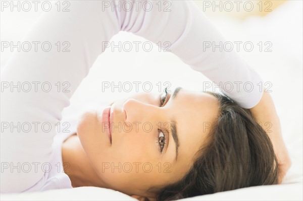 Portrait of woman lying in bed.