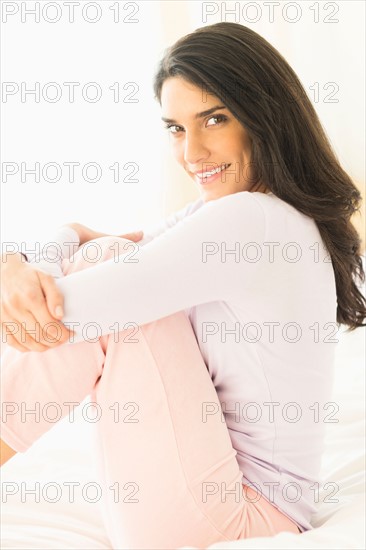 Woman sitting on bed.