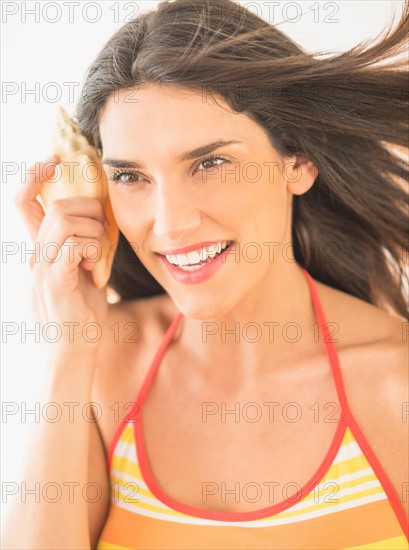 Woman listening to shell.