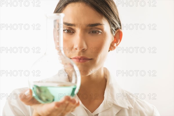 Woman holding beaker with liquid.