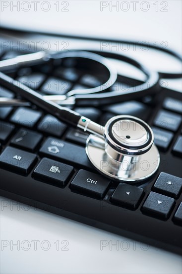 Close up of computer keyboard and stethoscope, studio shot.