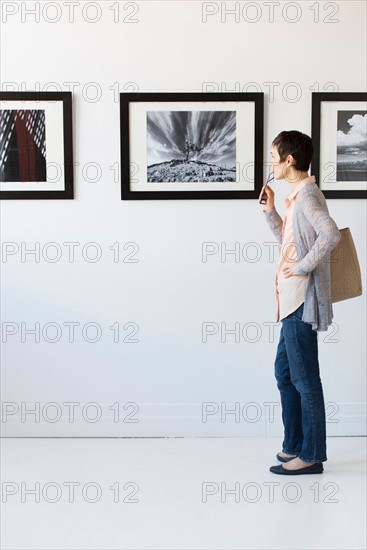 Woman watching photographs in art gallery.