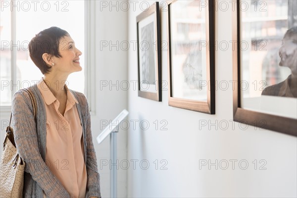 Woman watching photographs in art gallery.