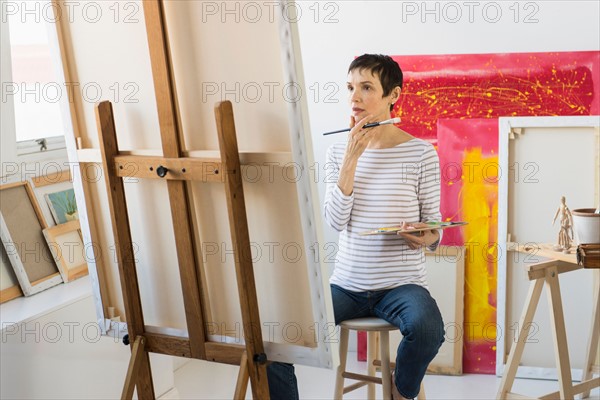 Female artist painting in her studio.