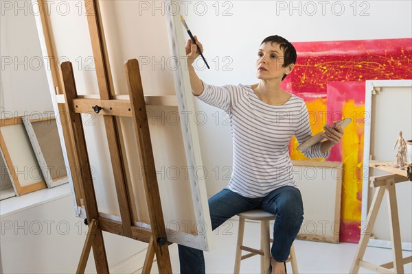 Female artist painting in her studio.