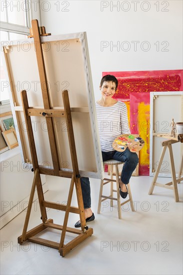 Female artist painting in her studio.