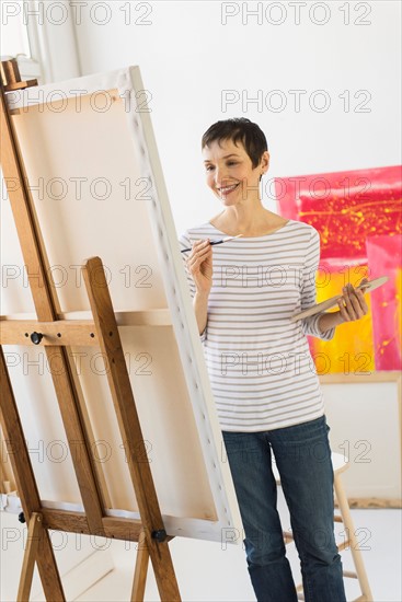 Female artist painting in her studio.