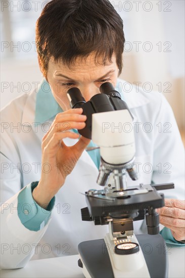 Woman working with microscope in laboratory.