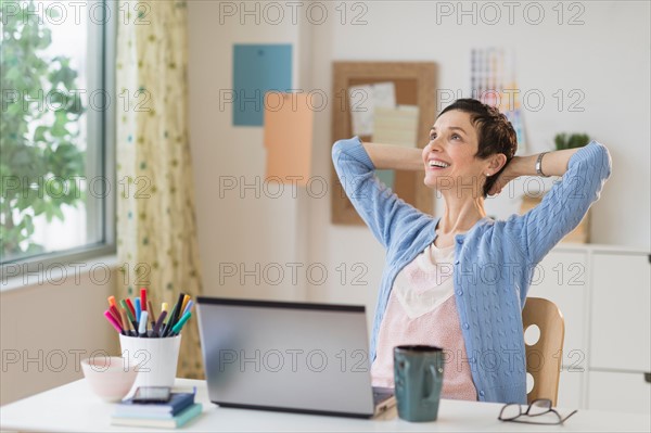 Woman relaxing in home office.