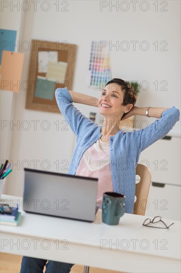 Woman relaxing in home office.