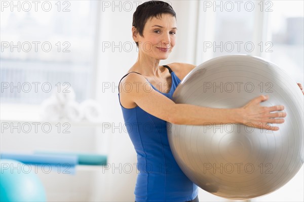 Portrait of mature woman exercising in gym.