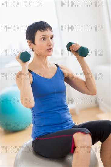 Mature woman exercising in gym.