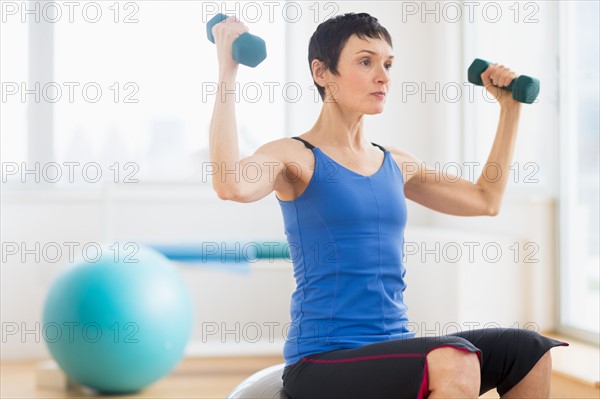 Mature woman exercising in gym.