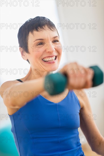 Mature woman exercising in gym.