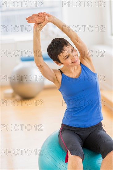 Mature woman exercising in gym.