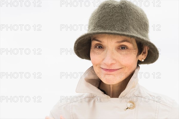 Portrait of smiling woman wearing raincoat and hat.