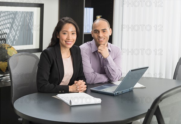 Portrait of man and woman at meeting in office.
