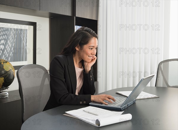 Businesswoman working at desk in office.