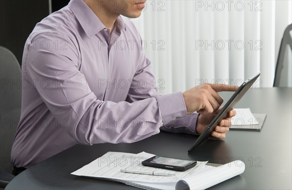 Male executive working at desk in office.