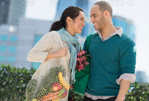 Happy couple with grocery shopping bags.