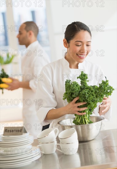 Couple during preparations in kitchen of their own restaurant.