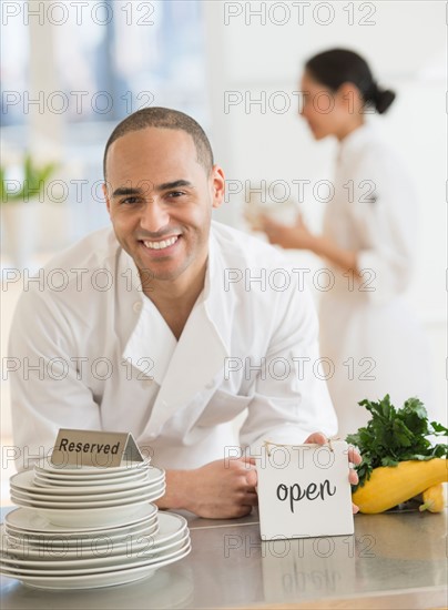 Couple during preparations in kitchen of their own restaurant.