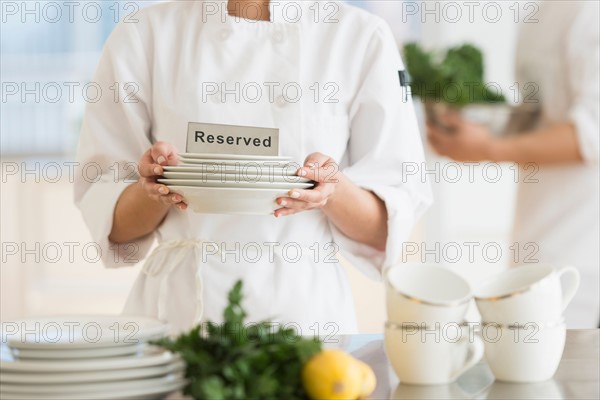 Couple during preparations in kitchen of their own restaurant.
