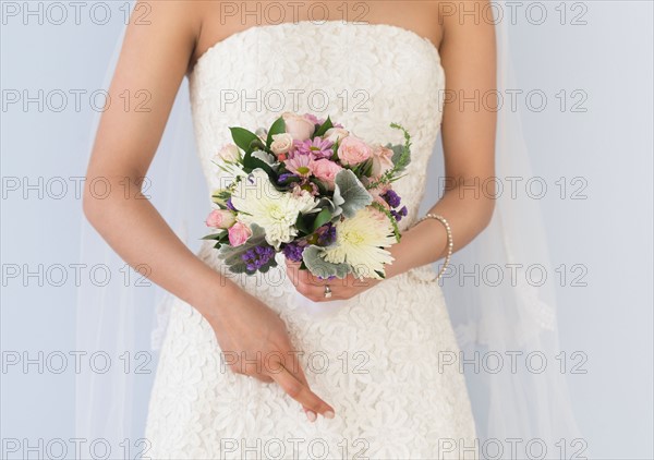 Bride in veil holding bouquet.