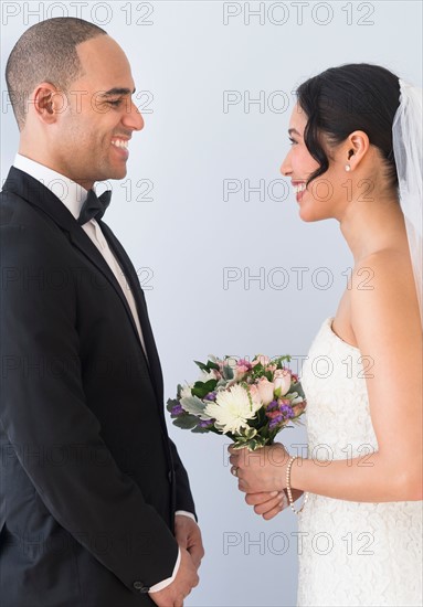 Bride and groom standing face to face.