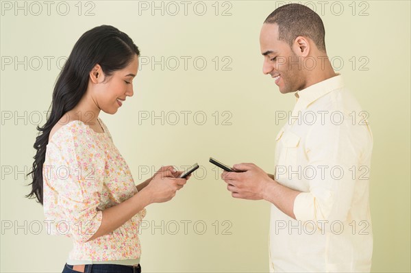 Young couple sending text messages simultaneously.