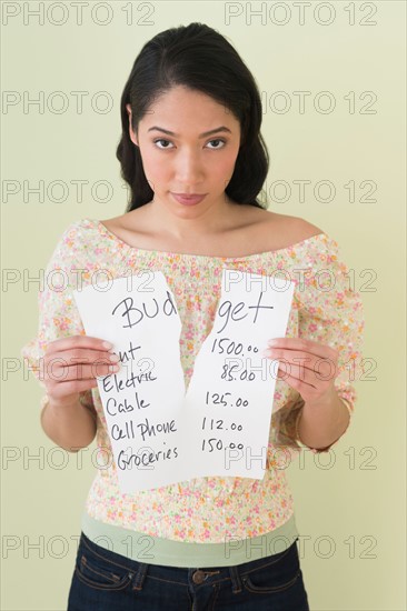 Young woman with torn list of expenses.