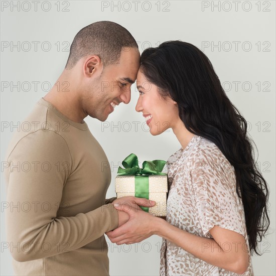 Portrait of young couple with anniversary present.