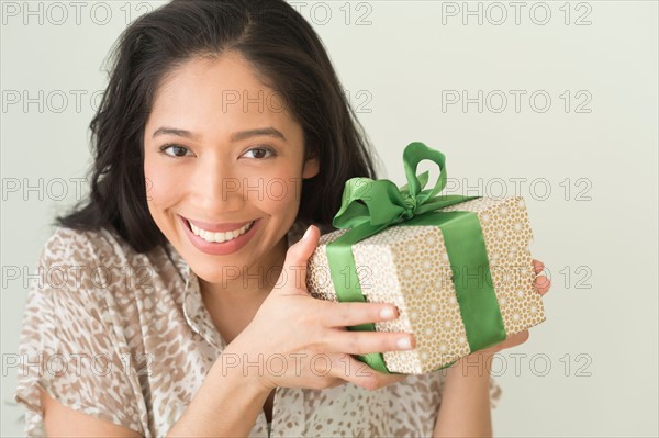 Young woman holding wrapped gift.