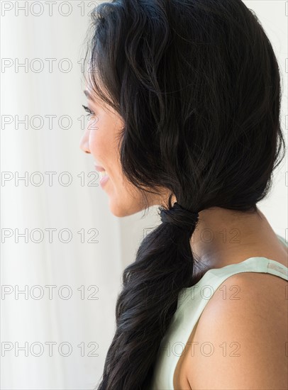 Young woman looking through window.