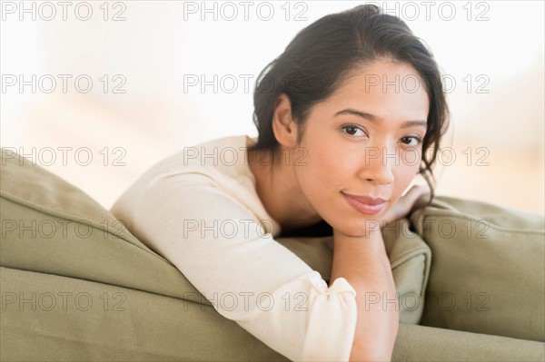 Portrait of young woman sitting on couch.