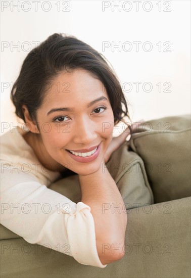 Portrait of young woman sitting on couch.