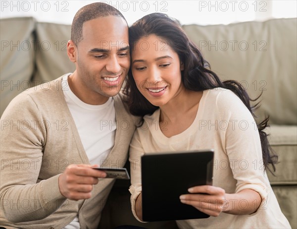 Young couple using digital tablets.