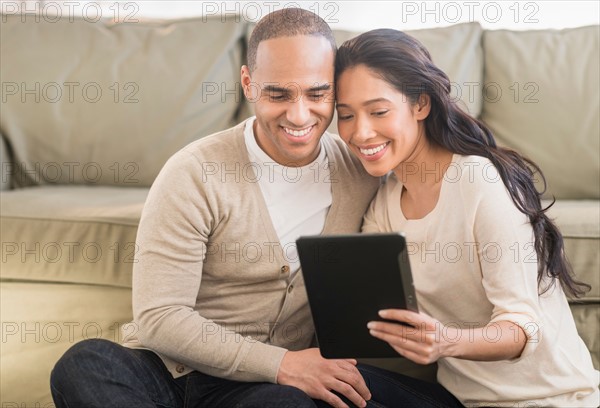 Young couple using digital tablets.