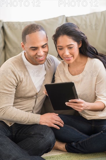 Young couple using digital tablets.