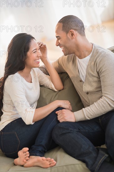Portrait of young couple sitting on couch.