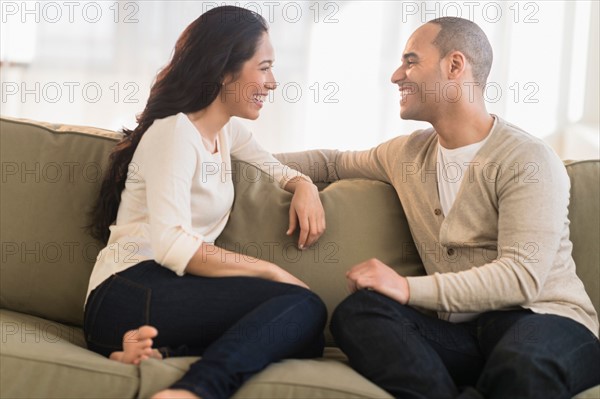 Portrait of young couple sitting on couch.