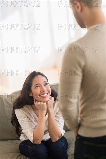 Young couple talking in livingroom.
