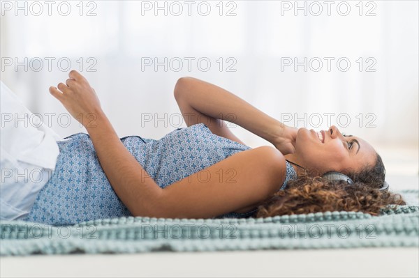 Young woman using phone lying on floor.