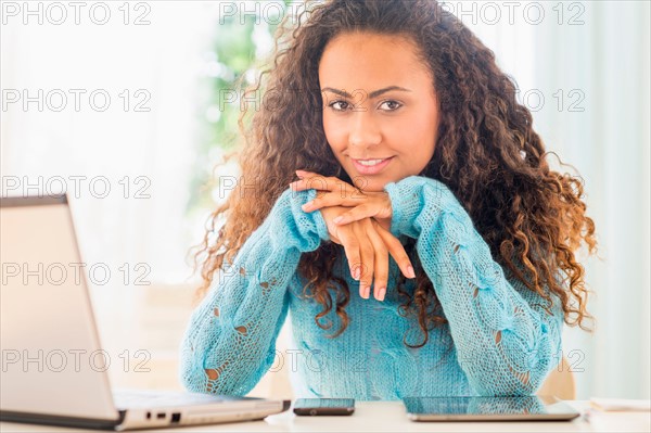 Young woman using laptop at home office.