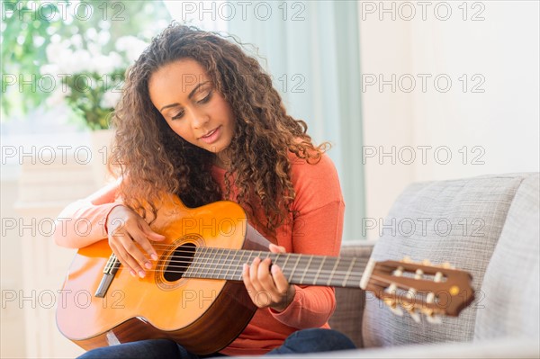 Young woman playing guitar.