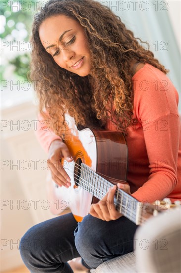 Young woman playing guitar.