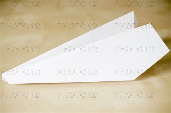 Paper plane on wooden surface