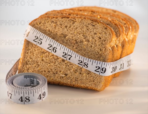 Studio Shot of measuring tape wrapped around slices of bread