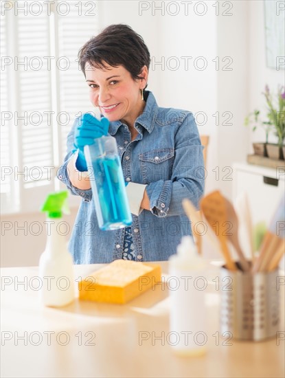 Portrait of mature woman cleaning kitchen