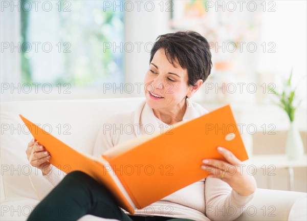 Portrait of mature woman looking at photo album